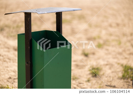 metal trash can on the beach on a sunny day. Conceptual photo of a clean beach 106104514