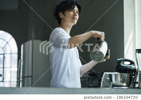 Man brewing coffee in a stylish kitchen Man brewing coffee in a stylish kitchen 106104720