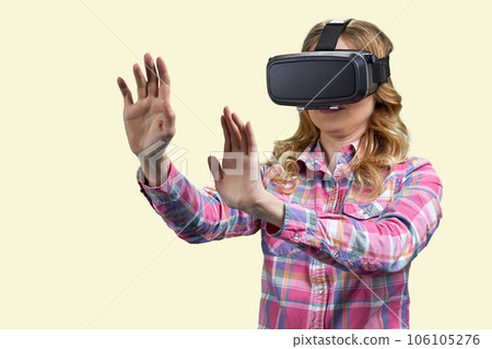 Woman wearing vr headsdet and touching something with both hands. Experiencing virtual reality simulation. Isolated on white. Woman wearing vr headsdet and touching something with both hands. Experiencing virtual reality simulation. Isolated on white. 106105276