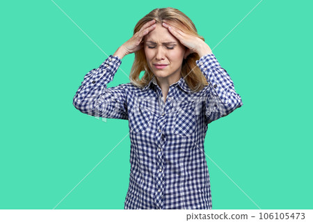 Portrait of stressed and frustrated young blonde woman. Touching head because of headache. 106105473