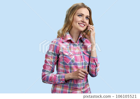 Portrait of young smiling blond woman is talking on mockup phone. Isolated on pastel blue background. 106105521