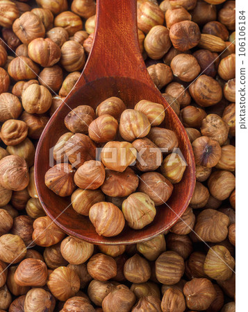Peeled hazelnuts. Hazelnut kernels lie in wooden spoon. Top view of nuts close-up. Advertising Peeled hazelnuts. Hazelnut kernels lie in wooden spoon. Top view of nuts close-up. Advertising 106106184