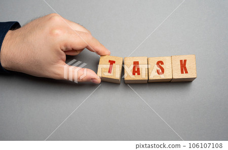 Task word concept. Business tasks and goal setting. Strategy and business management. Businessman holding wooden blocks Task word concept. Business tasks and goal setting. Strategy and business management. Businessman holding wooden blocks 106107108