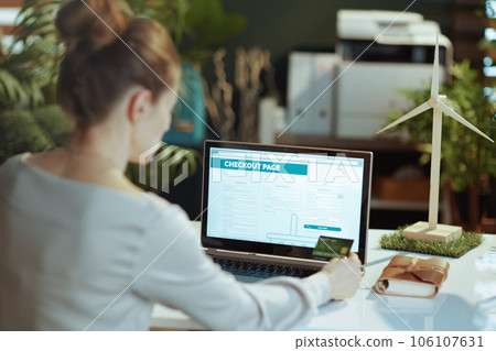 Seen from behind modern business woman browsing online shop Seen from behind modern business woman browsing online shop 106107631