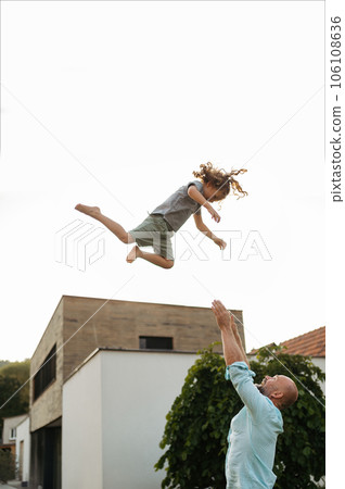 Father throwing little daugter up in the air. 106108636