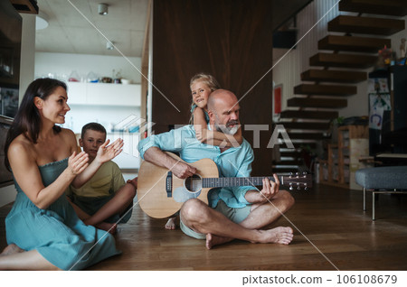 Father playing on guitar for his family. Father playing on guitar for his family. 106108679