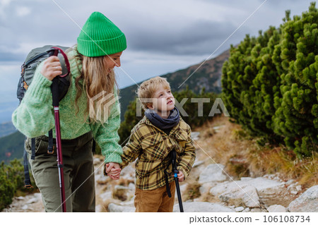 Active mother with little son hiking together in autumn mountains. 106108734