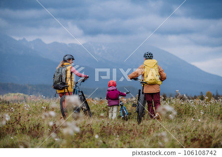 Young family with little daughter at bicycles, in the middle of autumn nature.Concept of a healthy lifestyle. 106108742