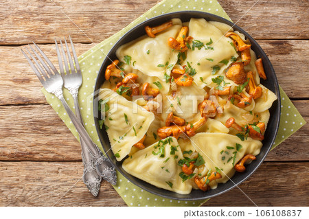 Portion of pasta triangoli stuffed with chanterelle mushrooms, onions and herbs close-up in a plate. Horizontal top view 106108837