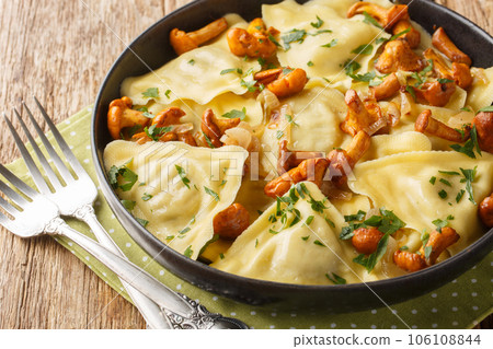 Italian pasta in the shape of a triangle stuffed with chanterelle mushrooms, onions and herbs close-up in a plate. Horizontal 106108844