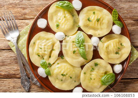 Authentic italian dumplings pasta cappellacci friarielli with mozzarella and herbs close-up in a plate. Horizontal top view Authentic italian dumplings pasta cappellacci friarielli with mozzarella and herbs close-up in a plate. Horizontal top view 106108853