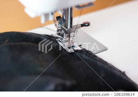 Sewing machine needle and black cloth closeup 106109614