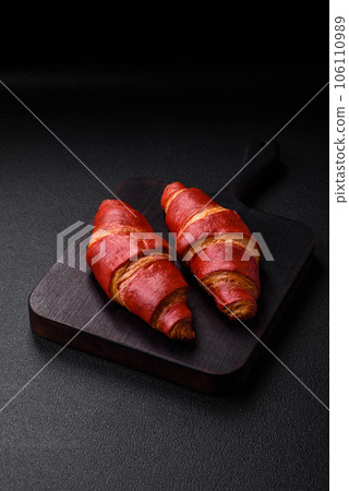 Delicious sweet crunchy red croissant with cream filling 106110989