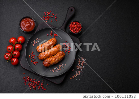 Delicious juicy grilled sausages with salt, spices and herbs 106111058