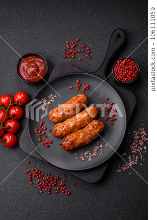 Delicious juicy grilled sausages with salt, spices and herbs 106111059