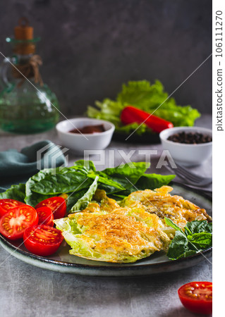 Young cabbage steaks, tomatoes and basil on a plate vertical view Young cabbage steaks, tomatoes and basil on a plate vertical view 106111270