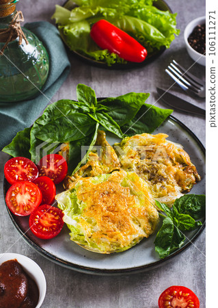 Baked cabbage steaks, fresh tomatoes and basil on a plate vertical view Baked cabbage steaks, fresh tomatoes and basil on a plate vertical view 106111271