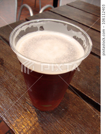 cold beer in an eco plastic glass (close-up photo) 106112403