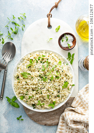 Cauliflower rice with herbs and lemon juice in a white bowl 106112677