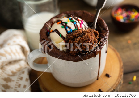Chocolate cake in a mug with ice cream and sprinkles Chocolate cake in a mug with ice cream and sprinkles 106112700