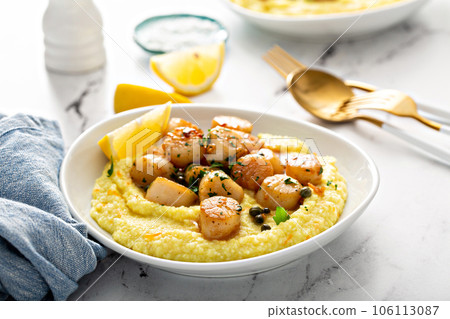Seared scallops with grits and lemon sauce 106113087