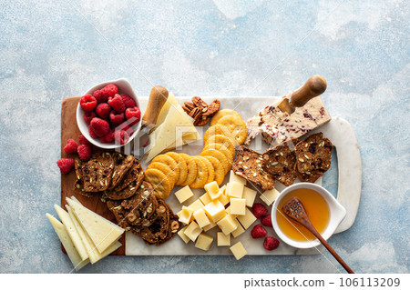 Cheese and snacks board with raspberry and crackers 106113209