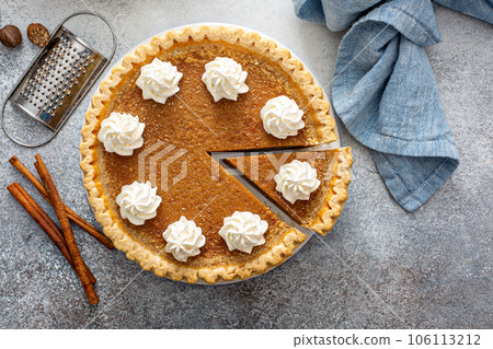 Traditional pumpkin pie with whipped cream and cinnamon Traditional pumpkin pie with whipped cream and cinnamon 106113212