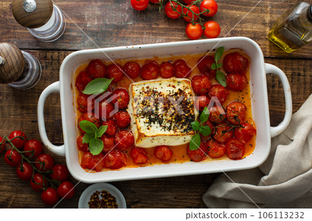 Baked feta cheese with cherry tomatoes in a pan 106113232