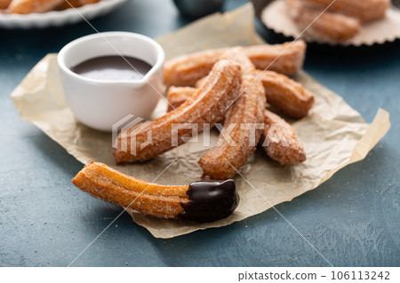 Homemade churros with cinnamon sugar on parchment 106113242
