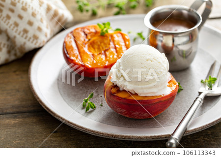 Grilled peaches with ice cream and caramel sauce, summer dessert Grilled peaches with ice cream and caramel sauce, summer dessert 106113343