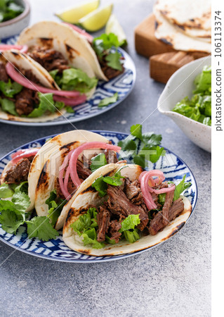 Beef tacos with lettuce and pickled red onion Beef tacos with lettuce and pickled red onion 106113374