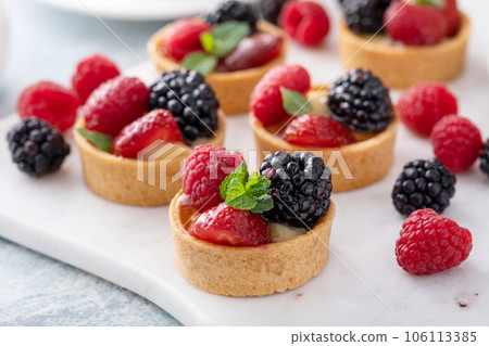 Fresh berries tartlets with custard filling and mint Fresh berries tartlets with custard filling and mint 106113385