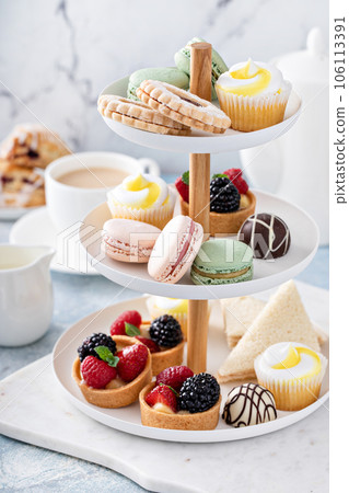 Spring or summer dessert table, three tiered tray with desserts 106113391