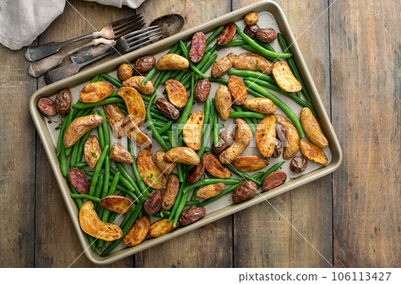 Roasted crispy fingerling potatoes with green beans on a sheet pan 106113427