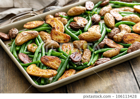 Roasted crispy fingerling potatoes with green beans on a sheet pan 106113428