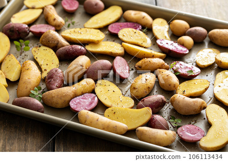 Yellow and purple fingerling potatoes on a baking sheet 106113434