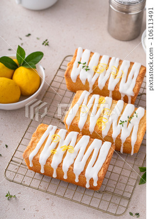 Classic lemon pound cake with powdered sugar glaze dripping over 106113491