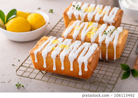 Classic lemon pound cake with powdered sugar glaze dripping over 106113492