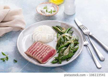 Seared tuna steak with white rice and green peas Seared tuna steak with white rice and green peas 106113541