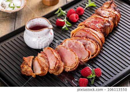 Pork tenderloin wrapped in bacon with raspberry vinaigrette Pork tenderloin wrapped in bacon with raspberry vinaigrette 106113550