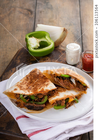 Brisket, peppers and onions quesadillas cut on a plate Brisket, peppers and onions quesadillas cut on a plate 106113564