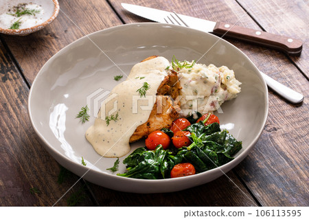 Roasted chicken thighs served with creamy sauce and mashed potatoes Roasted chicken thighs served with creamy sauce and mashed potatoes 106113595