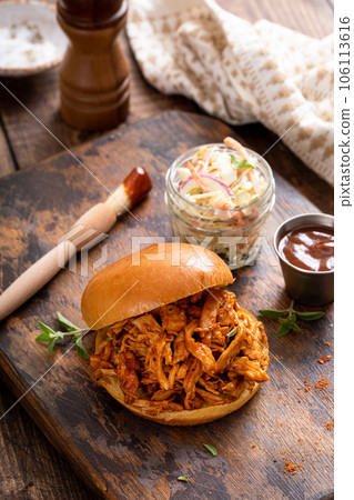 BBQ chicken sandwich on a brioche bun with coleslaw 106113616