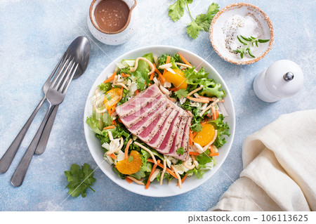 Seared tuna with asian crunchy salad with oranges 106113625