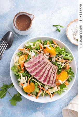 Seared tuna with asian crunchy salad with oranges 106113626