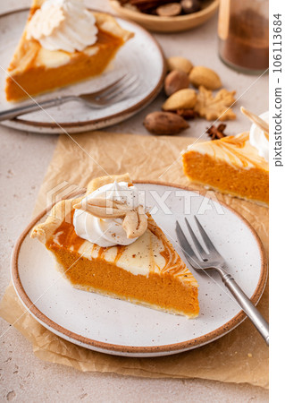 Pumpkin cheesecake swirl pie topped with whipped cream 106113684