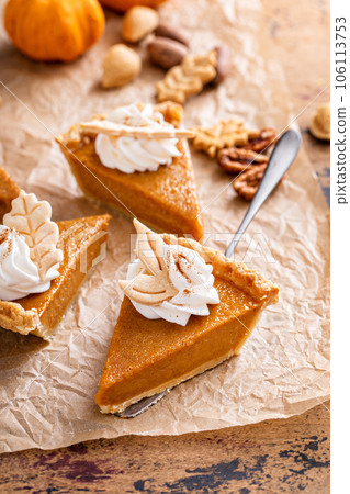 Festive pumpkin pie slices decorated with whipped cream 106113753