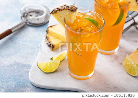 Pineapple rum cocktail with lime slices, refreshing summer cocktail 106113926