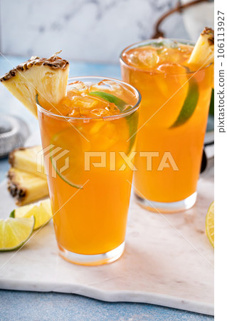 Pineapple rum cocktail with lime slices, refreshing summer cocktail Pineapple rum cocktail with lime slices, refreshing summer cocktail 106113927