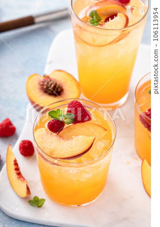 Refreshing summer cocktail with peach and raspberry 106113954